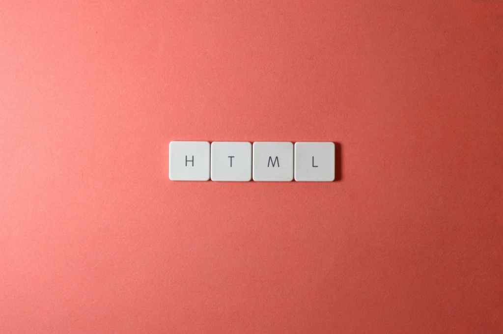 Small Tiles Spelling Out HTML On Top Of Red Background